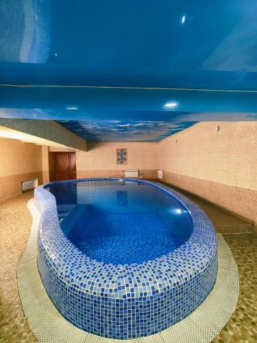 una grande piscina in un edificio con un soffitto blu di EventHouse a Almaty