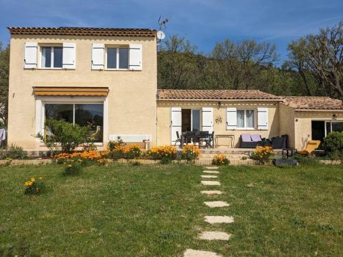 a house with a pathway in front of a yard at Villa calme avec piscine à Greoux in Gréoux-les-Bains