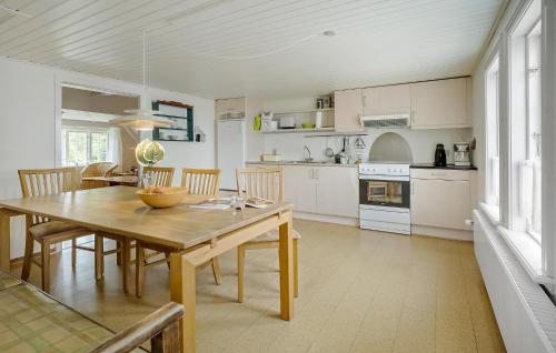 a kitchen and dining room with a wooden table and chairs at Stangegaard in Åkirkeby