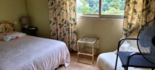 a bedroom with a bed and a window and a chair at Vue Mer Capitou in Mandelieu-la-Napoule