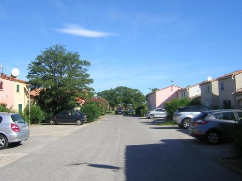une rue avec des voitures garées dans un parking dans l'établissement Maison de plage, à Saint-Cyprien