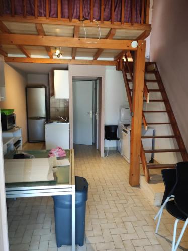 un salon avec un escalier et une cuisine dans l'établissement Maison de plage, à Saint-Cyprien