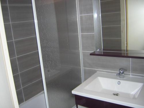 une salle de bain avec une douche, un lavabo et un miroir dans l'établissement Maison de plage, à Saint-Cyprien