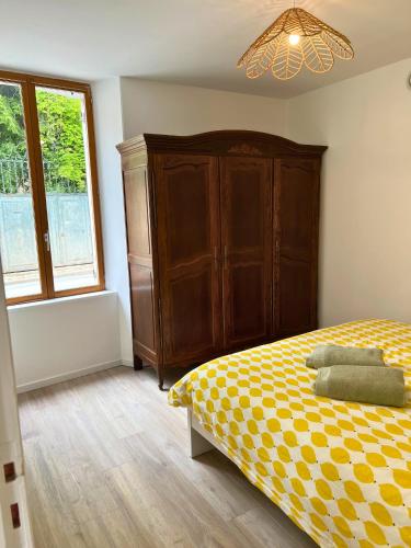 a bedroom with a bed and a cabinet and a window at Charmant gîte au cœur des vignes - Rive de Champagne in Vandières-sous-Chatillon