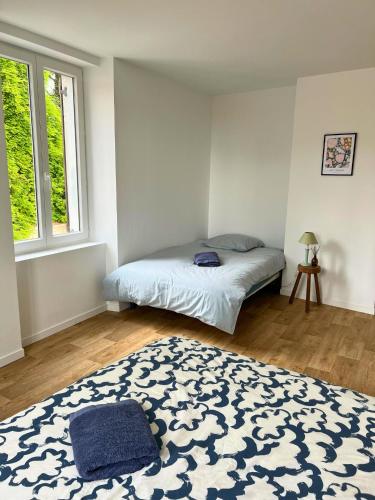a bedroom with a bed and a blue and white rug at Charmant gîte au cœur des vignes - Rive de Champagne in Vandières-sous-Chatillon