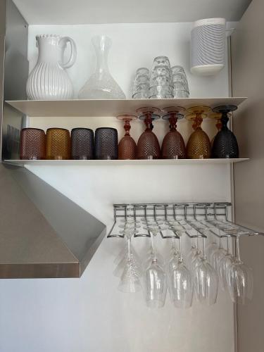 a shelf with glasses and vases on it at Private 250sqm Garden Duplex, Jacuzzi, Cinema, Sea View Escape in Torremolinos