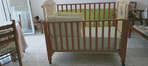 a crib in a room with a table and a crib at Vagelis 2 Nemea apartments in Neméa