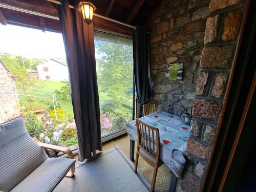 une pièce avec une table et une grande fenêtre dans l'établissement La Bouletière, à Dourbies