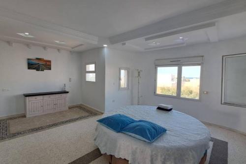 una stanza bianca con un letto e un tavolo di Résidence Lina Vue de mer avec piscine a Taguermess