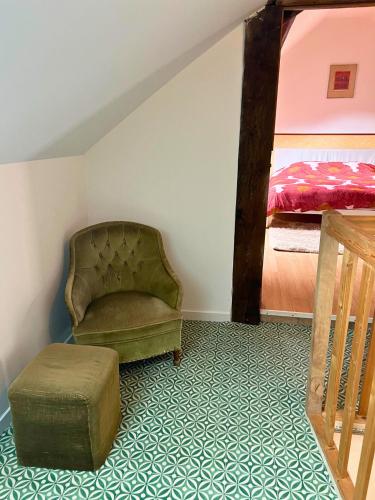 a living room with a chair and a bed at Charmant gîte au cœur des vignes - Rive de Champagne in Vandières-sous-Chatillon