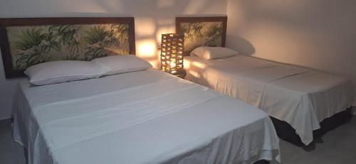 two beds sitting next to each other in a bedroom at Espaço Sairé - 8 minutos da Praia in Alter do Chao