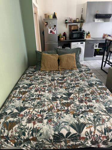 un lit dans une petite pièce avec une couverture colorée dans l'établissement Charmant studio situé en centre-ville, à Marseille