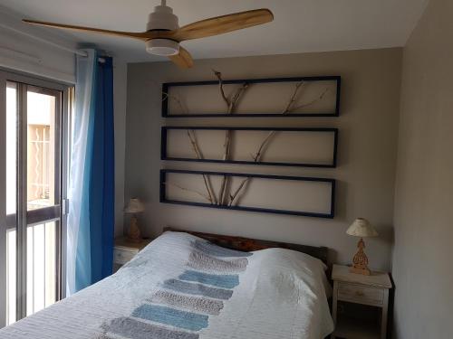 une chambre avec un lit et un ventilateur de plafond dans l'établissement Bellevue, à Six-Fours-les-Plages