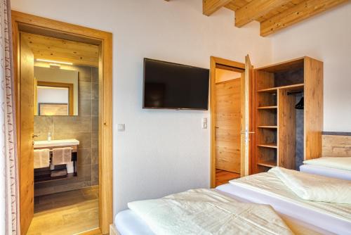 a bedroom with a bed and a bathroom with a sink at Apart Darre inclusive Super Sommer Card in Serfaus