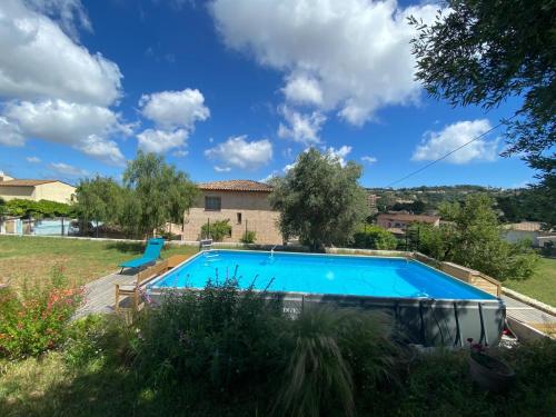 une piscine dans une cour avec une maison dans l'établissement Villa aux oliviers, climatisation, piscine et barbecue, à Vallauris