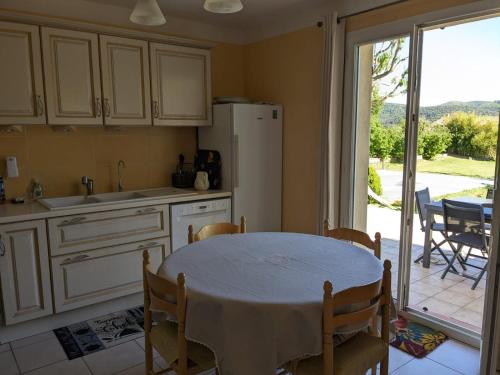 a kitchen with a table and a kitchen with a patio at Villa calme avec piscine à Greoux in Gréoux-les-Bains