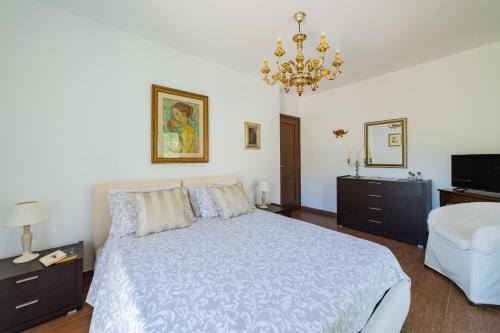 a bedroom with a bed and a chandelier at Villa Almond in Taormina