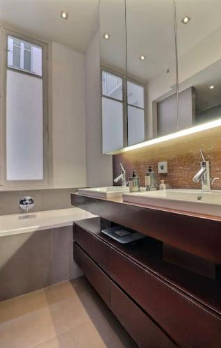 une salle de bain avec deux lavabos et un grand miroir dans l'établissement Luxury 3 Bedrooms Apartment near Champs Elysees, à Paris