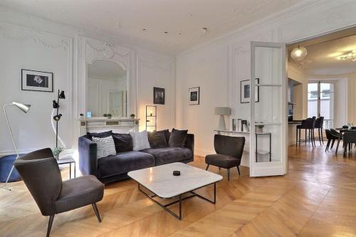 un salon avec un canapé et une table dans l'établissement Luxury 3 Bedrooms Apartment near Champs Elysees, à Paris