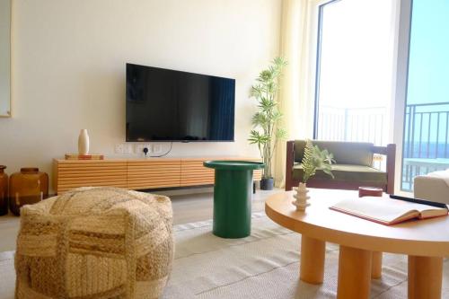 a living room with a flat screen tv on a wall at Classy 1BR High Floor by Amenities & F1 in Abu Dhabi