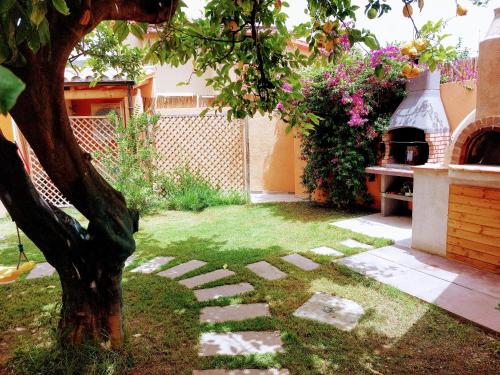 a garden with a tree and a stone path at villa Sara in Teulada