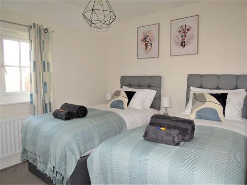 two beds in a bedroom with two bags on them at Impeccable Home with Parking in Bristol