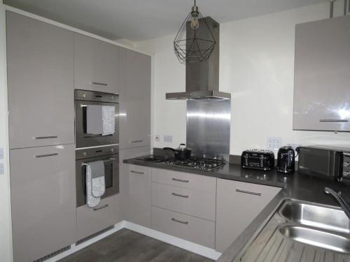 a kitchen with white cabinets and a stove top oven at Impeccable Home with Parking in Bristol