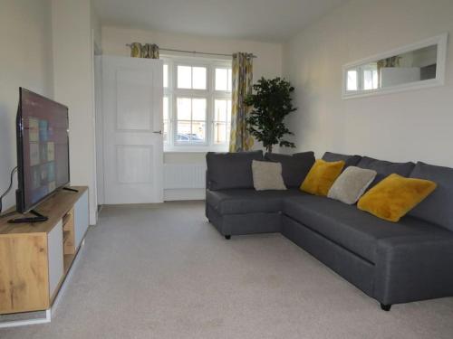 a living room with a gray couch and a television at Impeccable Home with Parking in Bristol