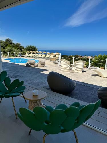a patio with chairs and a swimming pool at infinity Castellabate b & b di Charme in Santa Maria di Castellabate