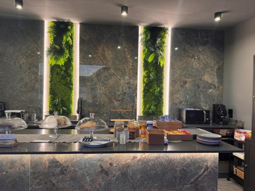 una cucina con bancone e piante sul muro di infinity Castellabate b & b di Charme a Santa Maria di Castellabate