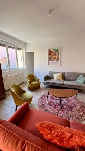 a living room with a couch and a table and chairs at Charmant gîte au cœur des vignes - Rive de Champagne in Vandières-sous-Chatillon