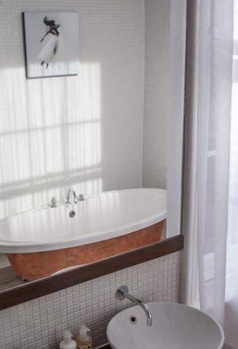 a bathroom with a bath tub and a sink at Lace Market Hotel in Nottingham