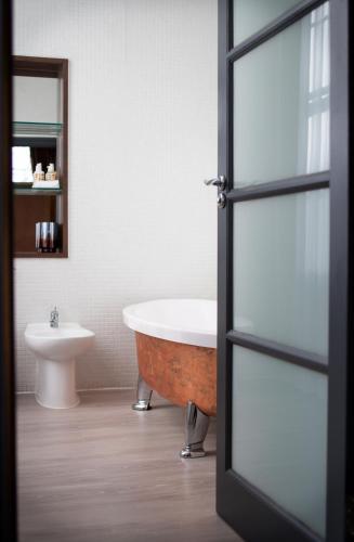 a bathroom with a bath tub and a toilet at Lace Market Hotel in Nottingham