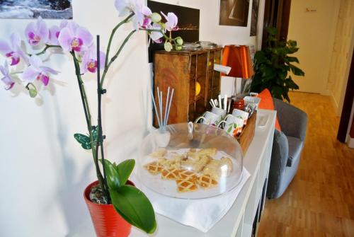 a table with a tray of food and flowers on it at B&B Pellicano Guest House in Reggio Calabria
