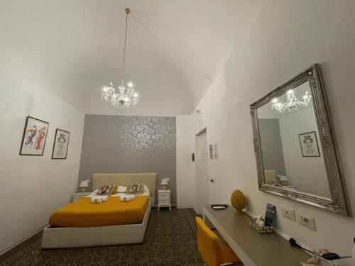 - une chambre avec un lit jaune et un miroir dans l'établissement Sleep Inn Catania rooms - Affittacamere, à Catane