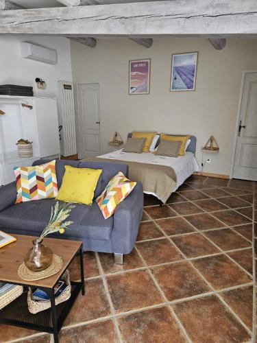 un salon avec un lit et un canapé dans l'établissement Gîte Le Refuge, à Monieux