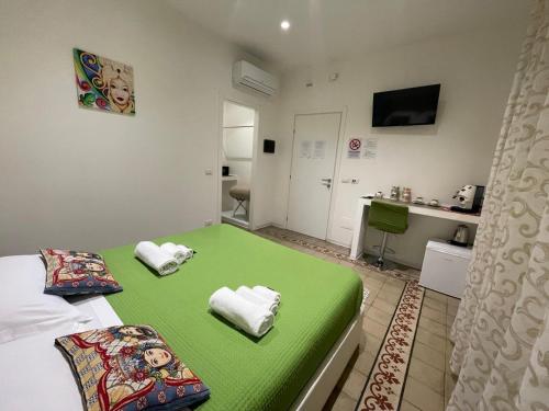 a small room with a green bed and a kitchen at Sleep Inn Catania rooms - Affittacamere in Catania