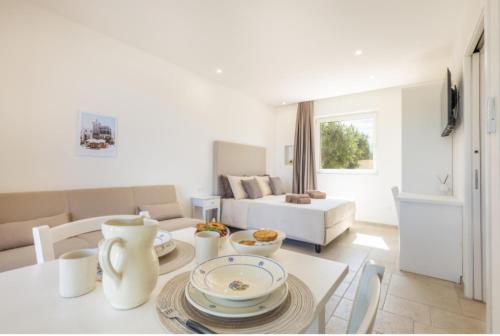a white living room with a table and a couch at Tenuta Sante in Serranova