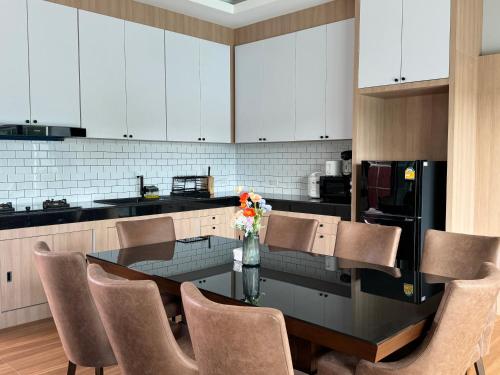 a kitchen with a table with chairs and a refrigerator at Sun Ray Private Pool villa 3 bed in Ao Nang