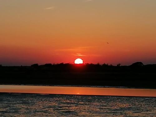 a sunset over a body of water with the sun at Teach Beag in Duncormick