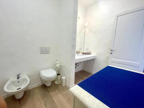 un bagno bianco con un water e un lavandino di San Teodoro PUNTA EST Vista Mare a Capo Coda Cavallo