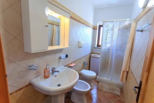 un bagno con lavandino, WC e doccia di Villa Alimini - Villetta con veranda Laghi Alimini a Otranto