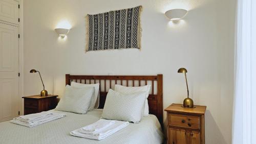 a bedroom with a bed with two night stands and two lamps at Villa charmosa V3 junto à praia e à Marina de Vilamoura in Quarteira