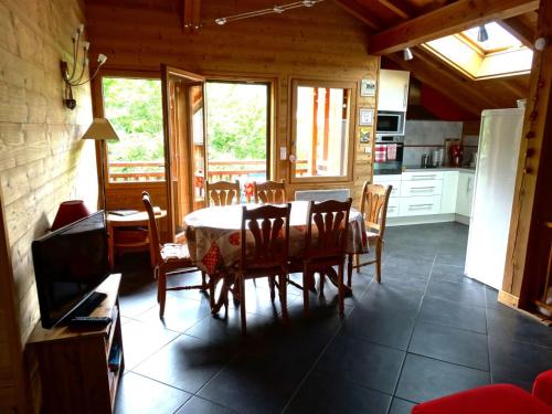 une cuisine et une salle à manger avec une table et des chaises dans l'établissement Appartement cosy à Samoëns avec jacuzzi, à Samoëns