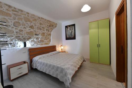 a bedroom with a bed and a green cabinet at B&B Tredomus in Tresnuraghes