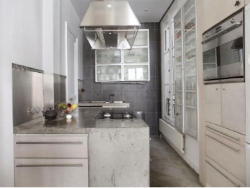 une cuisine blanche avec un évier et une cuisinière dans l'établissement appartment d'architecte, à Paris