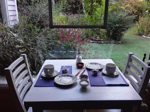 a table with plates and cups on top of it at Dodo House in Villa La Angostura