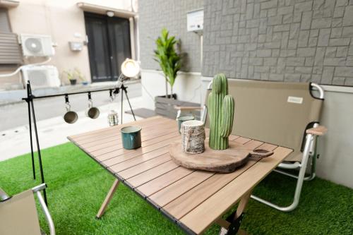 a wooden table with a cactus on top of it at Mi-Villa Kami-Ikebukuro in Tokyo