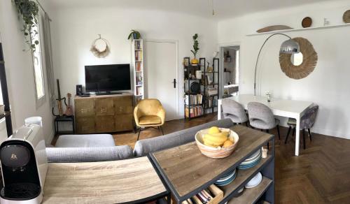 un salon avec une table avec un bol de fruits dessus dans l'établissement Beau T3 proche mer et aéroport, à Nice