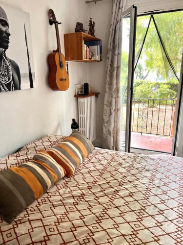 - une chambre avec un lit et une guitare sur le mur dans l'établissement Beau T3 proche mer et aéroport, à Nice